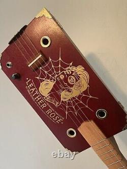 Guitare Cigar Box en cuir rose. Acoustique/Électrique. 4 cordes. Fabriquée à la main.